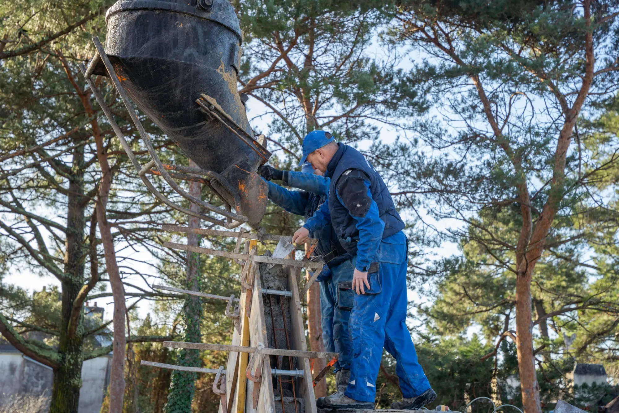 Photographe de chantier BTP en Morbihan — coulage de béton sur un chantier Photographe de chantier BTP dans le Morbihan : maçon coulant du béton dans un coffrage sur un chantier