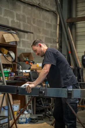 Ouvrier sur une pièce métallique en atelier