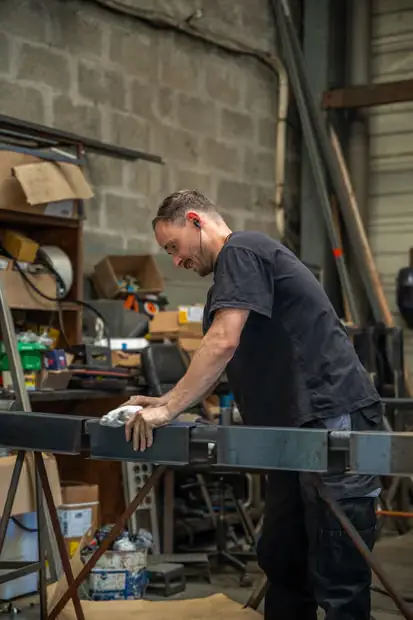 Ponçage d’une pièce métallique en atelier à Lorient
