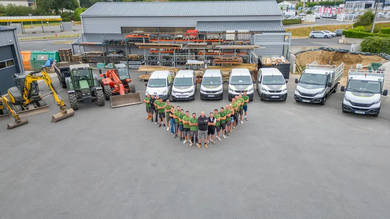 Vue aérienne par drone d’une équipe d’entreprise rassemblée devant son dépôt en Bretagne