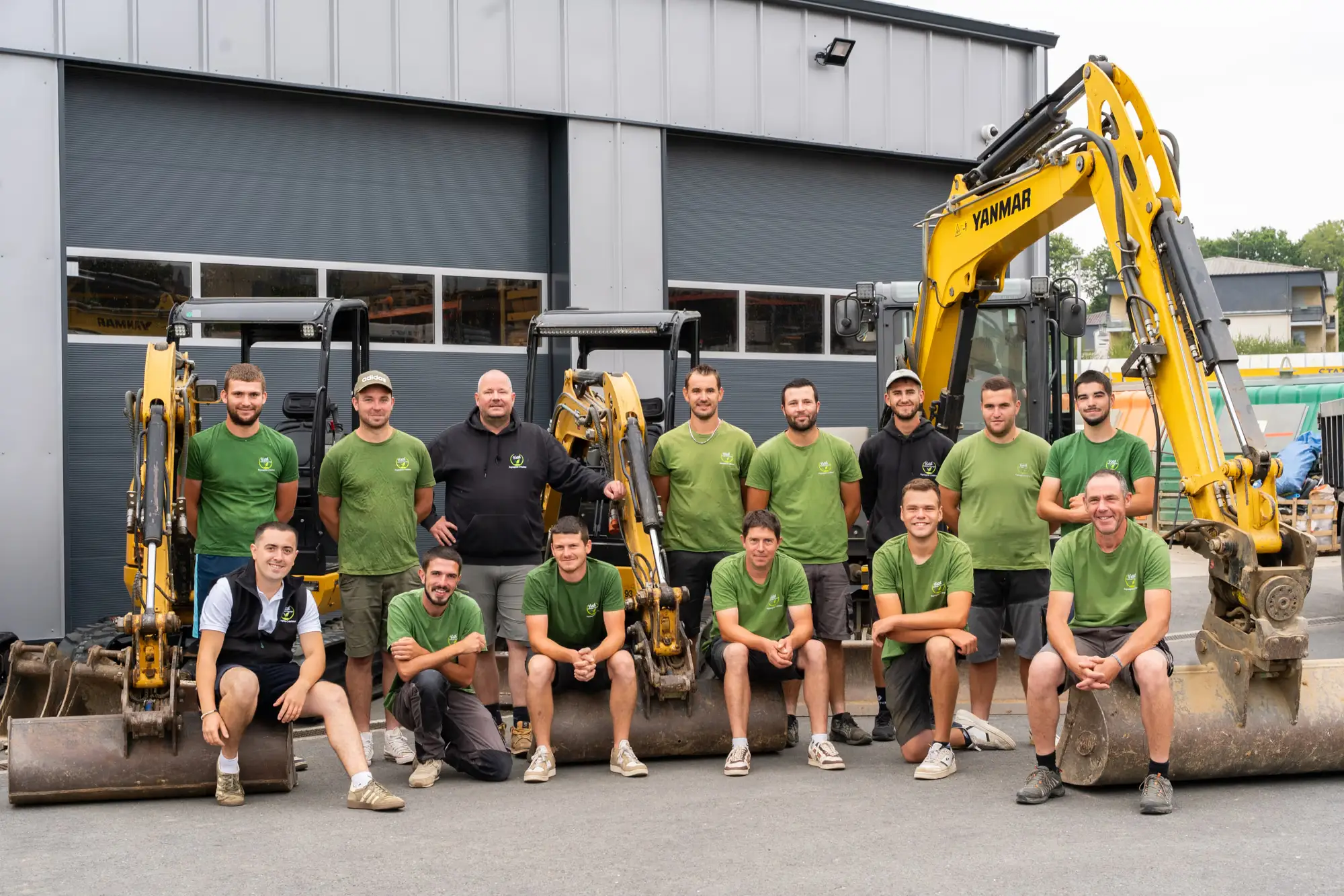 Collaborateurs présentant des godets d’engins devant leur atelier, en Bretagne