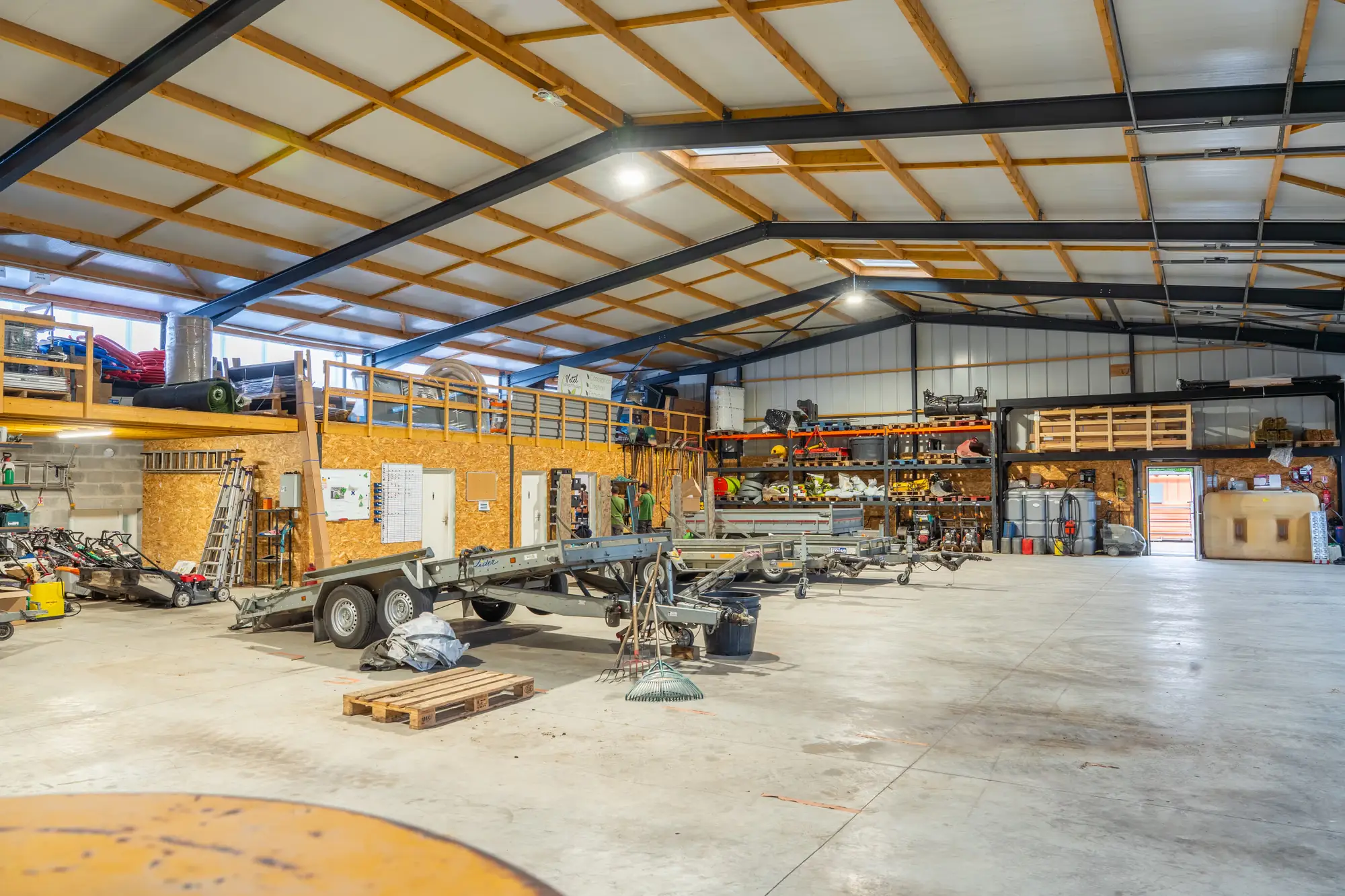 Intérieur d’un hangar d’entreprise, matériel aligné et zone de stockage, en Bretagne
