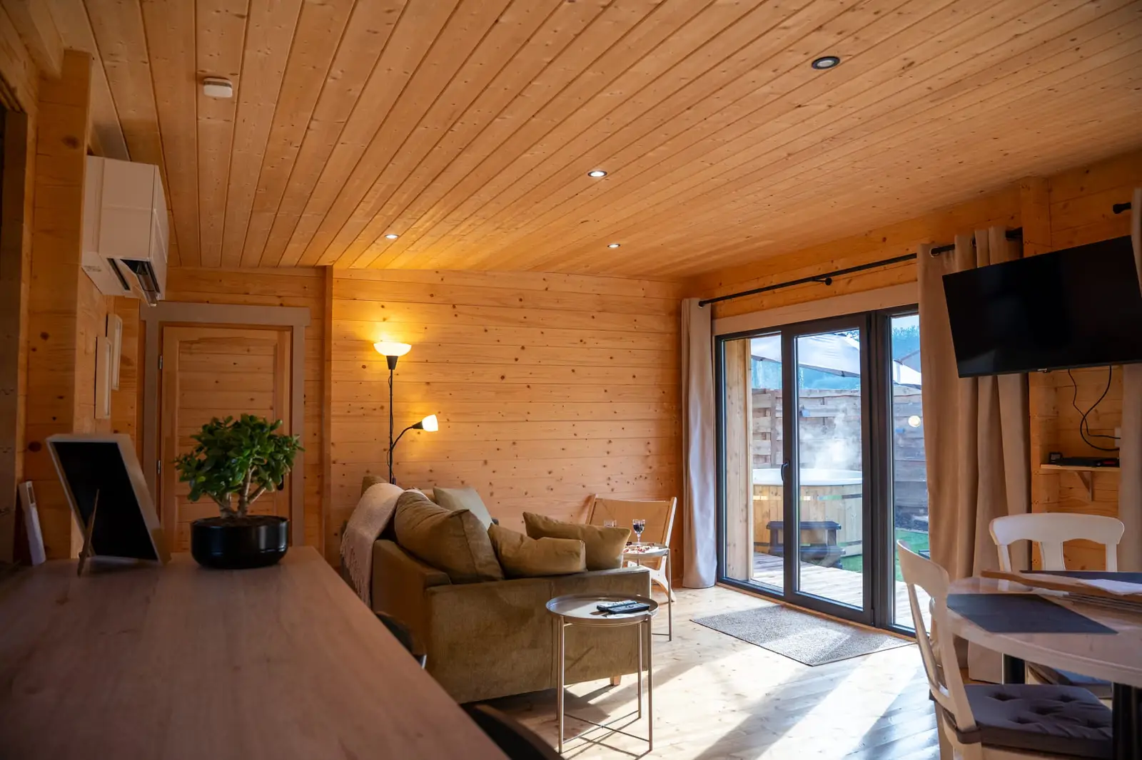 Salon en bois d’un gîte de charme ouvrant sur le spa extérieur, Morbihan